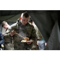 Un soldat britannique prend son repas à l'ordinaire du camp du Royal Logistic Corps à Vouziers.