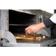 Un cuisinier prépare le repas à l'ordinaire de campagne de Vouziers.