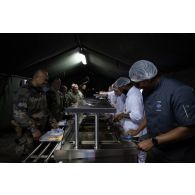 Des cuisiniers du groupement de soutien de base de Défense (GSBdD) d'Angoulême servent le repas des troupes à l'ordinaire du camp de Vouziers.