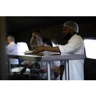 Des cuisiniers du groupement de soutien de base de Défense (GSBdD) d'Angoulême servent le repas des troupes à l'ordinaire du camp de Vouziers.