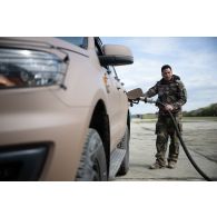 Un soldat du 121e régiment du train (RT) fait le plein en carburant d'un véhicule tactique VT4 à Vouziers.