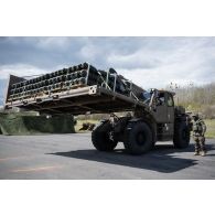 Des soldats du Service interarmées des munitions (SIMu) chargent des caisses de munitions au moyen d'un chariot Manitou sur le camp de Vouziers.