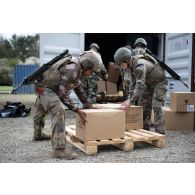 Des soldats du 14e régiment de soutien logistique parachutiste (RISLP) déchargent des rations alimentaires depuis un container sur le camp de Vouziers.