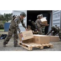 Des soldats du 14e régiment de soutien logistique parachutiste (RISLP) déchargent des rations alimentaires depuis un container sur le camp de Vouziers.