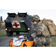 Un infirmier du régiment médical (RMED) encadre l'évacuation d'un soldat jouant un blessé pour un exercice sanitaire à Vouziers.