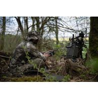 Un chef de peloton du 2e régiment de hussards (RH) met en oeuvre les moyens de transmissions d'une cache d'observation en forêt de Ville-sous-la-Ferté.