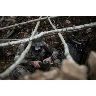 Un chef de peloton du 2e régiment de hussards (RH) met en oeuvre les moyens de transmissions d'une cache d'observation en forêt de Ville-sous-la-Ferté.