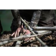 Un soldat du 2e régiment de hussards (RH) construit une cache d'observation en forêt de Ville-sous-la-Ferté.