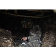 Un chef de peloton du 2e régiment de hussard (RH) met en oeuvre les transmissions d'une cache d'observation en forêt de Ville-sous-la-Ferté.