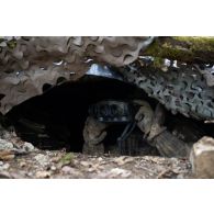 Un soldat du 2e régiment de hussards (RH) observe la zone au moyen de jumelles infrarouges multifonction (JIM LR 2) depuis une cache d'observation en forêt de Ville-sous-la-Ferté.