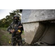 Un soldat du 16e bataillon de chasseurs (BCh) progresse à couvert d'un véhicule blindé de combat d'infanterie (VBCI) à Mourmelon.