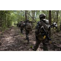 Des soldats du 16e bataillon de chasseurs (BCh) progressent en forêt de Mourmelon.