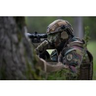 Un soldat belge des chasseurs ardennais se tient posté derrière un arbre à Suippes.