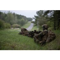 Des soldats belges des chasseurs ardennais surveillent la route depuis un fossé en forêt de Suippes.