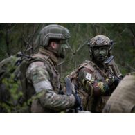 Un chef de section belge des chasseurs ardennais transmet ses instructions aux hommes de son unité pour une progression en forêt de Suippes.