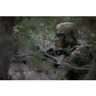 Un soldat belge des chasseurs ardennais tient une position à couvert des arbres en forêt de Suippes.