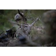 Un soldat belge des chasseurs ardennais tient une position à couvert des arbres en forêt de Suippes.