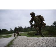 Des soldats belges des chasseurs ardeinnais franchissent un talus pour monter à l'assaut d'une position ennemie à Suippes.