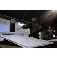 Un major britannique dirige un briefing sur carte au centre opérationnel de Mourmelon.