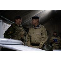 Le général Rémy Cadapeaud écoute un briefing auprès d'un major britannique au centre opérationnel de Mourmelon.