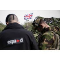 Un officier image de l'ECPAD discute avec un officier britannique au centre opérationnel de Mourmelon.