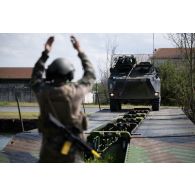 Un sapeur du 13e régiment du génie (RG) guide un véhicule de l'avant blindé (VAB) sur des travures pour le franchissement de l'Aisne à Guignicourt.