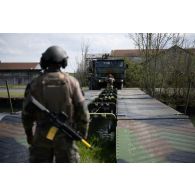 Des sapeurs du 13e régiment du génie (RG) guident un moyen d'amélioration de la traficabilité des sols (MATS) sur des travures pour le franchissement de l'Aisne à Guignicourt.