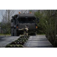 Un sapeur du 13e régiment du génie (RG) guide un un véhicule britannique de support logistique (LSV) sur des travures pour le franchissement de l'Aisne à Guignicourt.