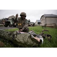 Un personnel du Service de santé des armées (SSA) pose une perfusion sanguine à un soldat simulant une blessure en attente de son évacuation à Saint-Germainmont.