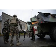 Une équipe médicale du Service de santé des armées (SSA) évacue un soldat simulant une blessure à bord d'un véhicule de l'avant blindé sanitaire (VAB SAN) à Saint-Germainmont.