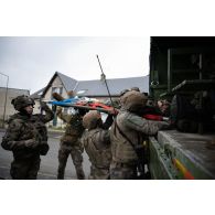 Une équipe médicale du Service de santé des armées (SSA) évacue un soldat simulant une blessure à bord d'un véhicule de l'avant blindé sanitaire (VAB SAN) à Saint-Germainmont.