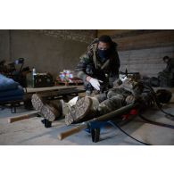 Un personnel du Service de santé des armées (SSA) soigne un soldat simulant une blessure au Rôle 1 de Saint-Germainmont.