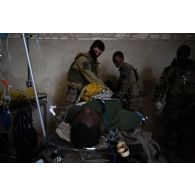 Des auxiliaires sanitaires du Service de santé des armées (SSA) soignent un soldat simulant une blessure au Rôle 1 de Saint-Germainmont.