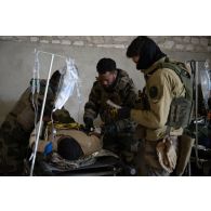 Des auxiliaires sanitaires du Service de santé des armées (SSA) soigne un soldat simulant une blessure au Rôle 1 de Saint-Germainmont.