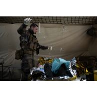 Un infirmier du Service de santé des armées (SSA) pose une perfusion sur une soldat simulant une blessure grave à l'antenne chirurgicale de Dizy-le-Gros.