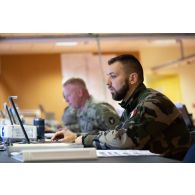 Un soldat du corps de réaction rapide-France (CRR-FR) travaille avec des soldats américains au centre opérationnel de Mailly-le-Camp.