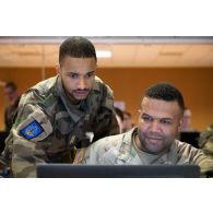 Un agent de liaison du corps de réaction rapide-France (CRR-FR) travaille avec un soldat américain au centre opérationnel de Mailly-le-Camp.
