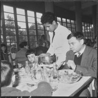 Ben-Aknoun. Ecole hôtelière. Un élève serveur sert une famille.