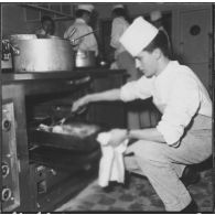 Ben-Aknoun. Ecole hôtelière. Le poulet est à point, le futur cuisinier le surveille d'un oeil attentif.