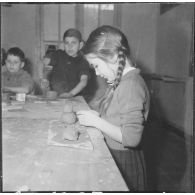 Le club du jeudi en Algérie. Une enfant joue avec de la pâte à modeler.