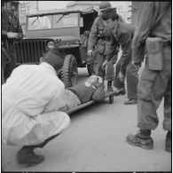 Bab el Oued. Fusillade sur le 2e bataillon du 73e régiment d'infanterie de marine (RIMa). Un gendarme blessé est amené dans un camion sanitaire.