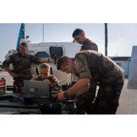 Des techniciens en systèmes d'information et de communication (SIC) configurent l'ordinateur d'un poste de commandement à Deir Kifa, au Sud-Liban.