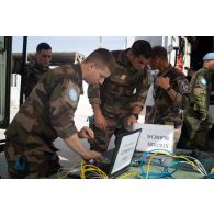 Des techniciens en systèmes d'information et de communication (SIC) configurent des ordinateurs d'un poste de commandement à Deir Kifa, au Sud-Liban.