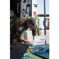 Un technicien en systèmes d'information et de communication (SIC) configure le réseau mobile (REMO) d'un poste de commandement à Deir Kifa, au Sud-Liban.