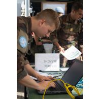 Un technicien en systèmes d'information et de communication (SIC) configure l'ordinateur d'un poste de commandement à Deir Kifa, au Sud-Liban.