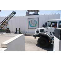 Un casque bleu sécurise l'arrivée d'un camion GBC-180 à la porte principale du camp de Deir Kifa, au Sud-Liban.