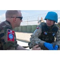 Une casque bleu français discute avec un médecin polonais pour la prise en charge d'un blessé à Nabatieh, au Sud-Liban.