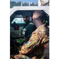 Un soldat du 1er régiment de spahis (RS) présente l'intérieur d'un véhicule blindé léger (VBL) à son homologue italien à Al Mansouri, au Sud-Liban.