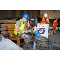 Un responsable du 519e régiment du train (RT) supervise l'embarquement de matériel à bord du cargo-roulier MN Tangara à Beyrouth, au Liban.
