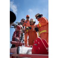 Un sapeur-pompier de la brigade de sapeurs-pompiers de Paris (BSPP) présente une lance incendie à des pompiers malaisiens à Marakah, au Sud-Liban.